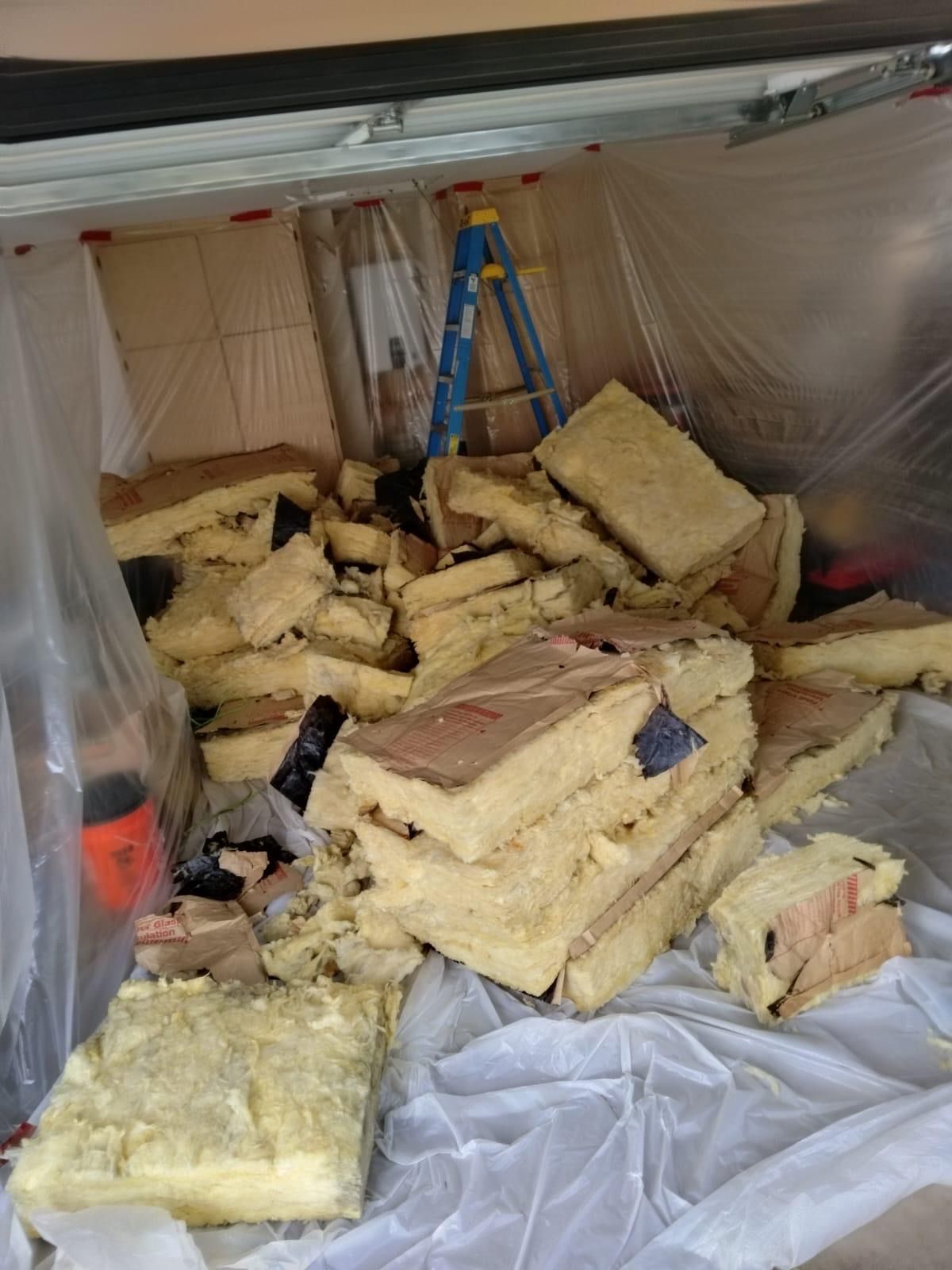 Old batt insulation being removed from an attic